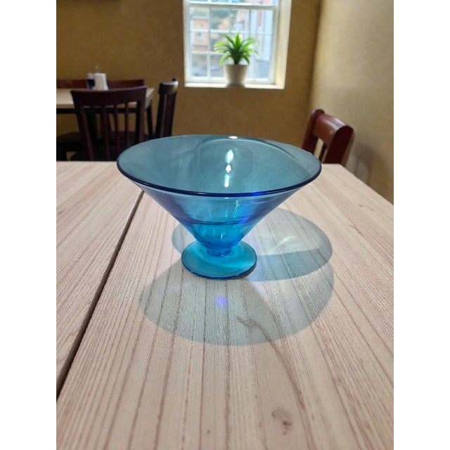 The Vintage Blue Glass Attributed Blenko Compote Pedestal Vase is a stylish and unique piece of décor from the Mid 20th...