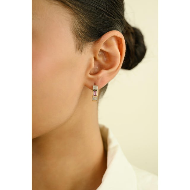 These elegant huggie hoop earrings feature 2 octagon cut pink sapphire 0.68 carats, set in rich 14k yellow gold. Each...