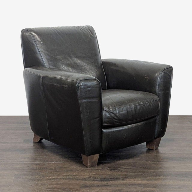This Natuzzi lounge armchair features genuine leather upholstery and sturdy wooden legs. Its wide seat and cushioned arms...