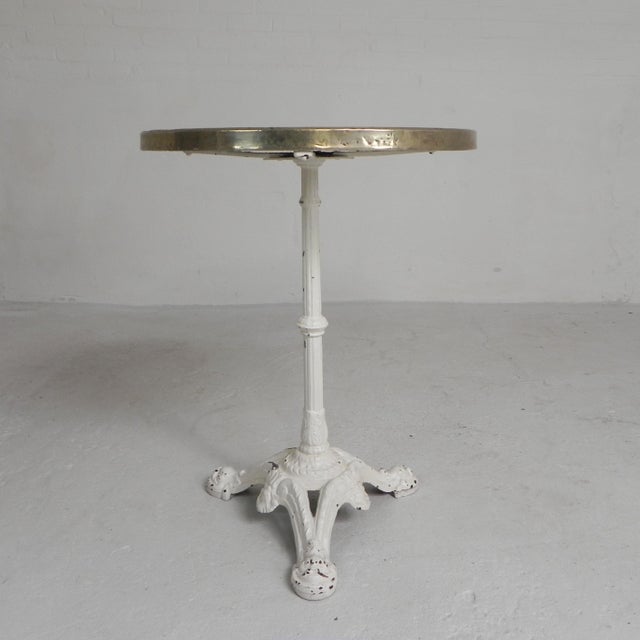 Elegant bistro table from the 1920s with robust cast iron legs and a luxurious marble top. The round marble top rests in a...