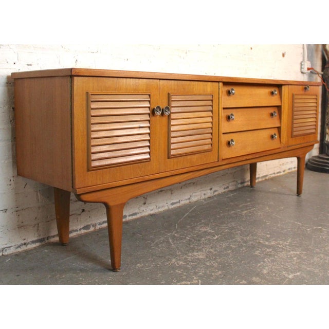 This low profile sideboard features a louvered design throughout the front. Center bank of drawers are angled out for...