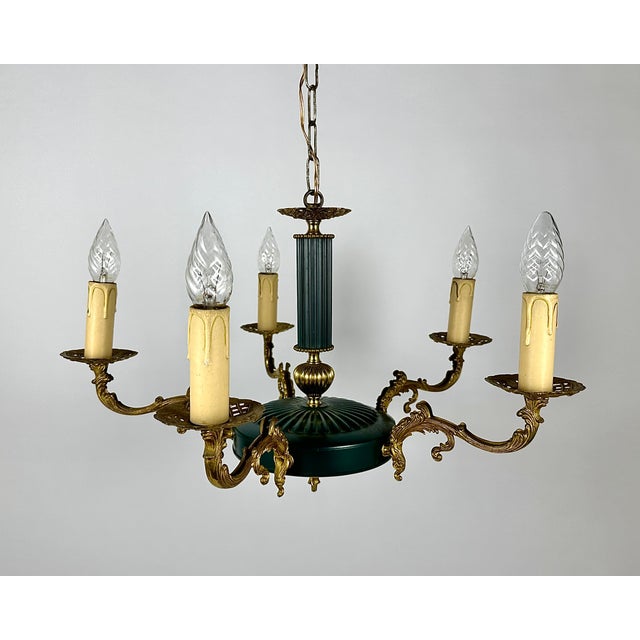 An elegant vintage chandelier with 5 arms in the empire style. the base is made of bronze and metal of green and gold...