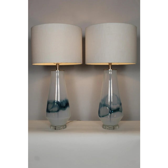 A pair of Seguso Style lamps. Sleek design . Hand blown cloudy pearl white with midnight blue abstract blend. Captures...