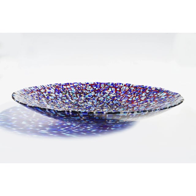 This round centerpiece is made of Murano glass. It features mainly blue base colors with Venetian red veins, precious gold...