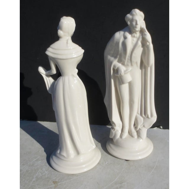 Early 20th-century pair of porcelain figures from Germany. A young couple in a romantic suggestive posture, She demures...