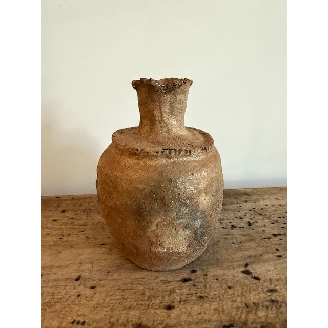 Antique Anatolian clay vessel with beautifully aged texture and organic form. This Turkish pottery piece features a warm...
