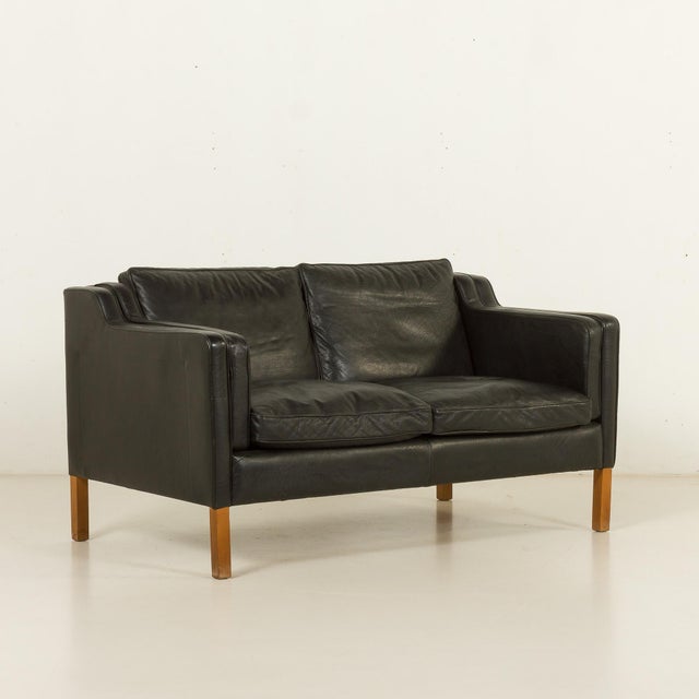This stouby black leather sofa, produced in denmark in the 1970s, is a refined example of late mid-century scandinavian...