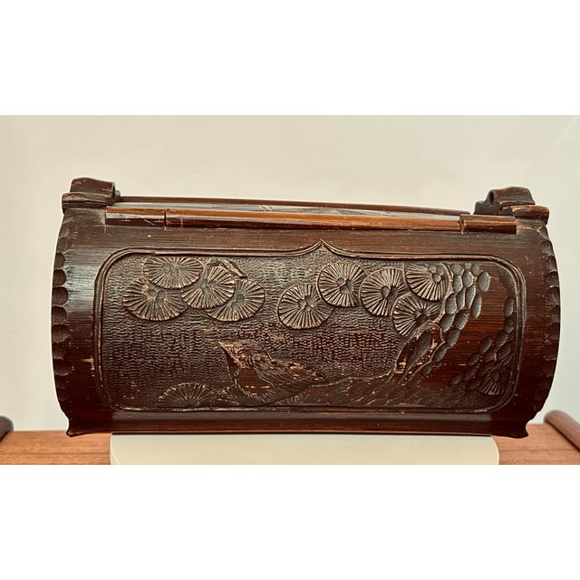 Antique Chinese carved bamboo water carrier. Bird in pine tree on one side and floral pattern on the other. End have an...