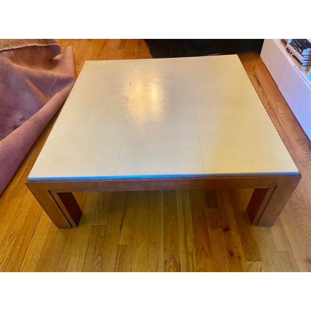 Striking square coffee table by Ralph Lauren, combining a cream leather paneled top with a warm cherry wood base and...