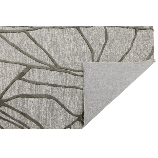 Elevate your living space with this sophisticated hand-tufted wool rug, featuring a striking abstract geometric pattern....