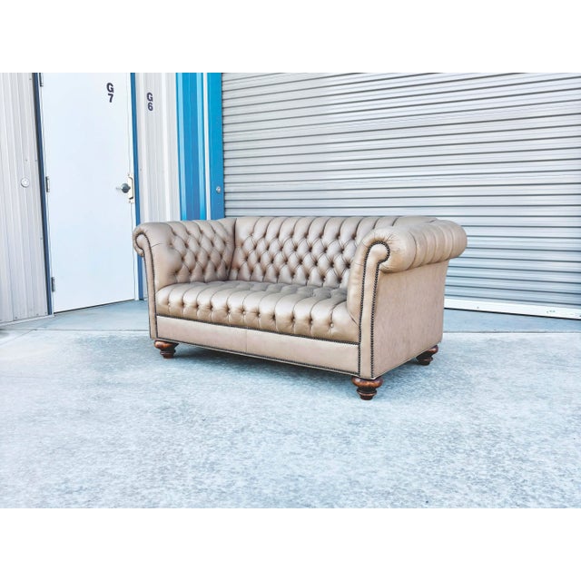 Exuding timeless British style and club-chair sophistication, this 1970s vintage Chesterfield loveseat is upholstered in a...