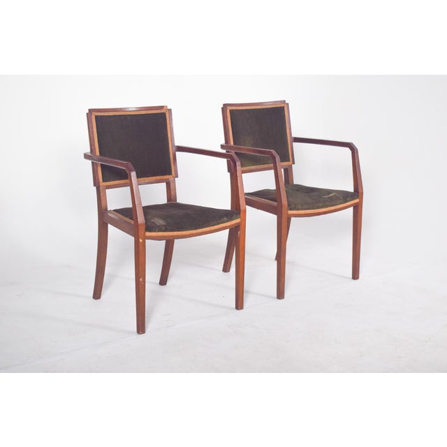 Pair of chairs with armrests, upholstered in green. Modernist in design, possibly dating from the 1940s, they have a solid...