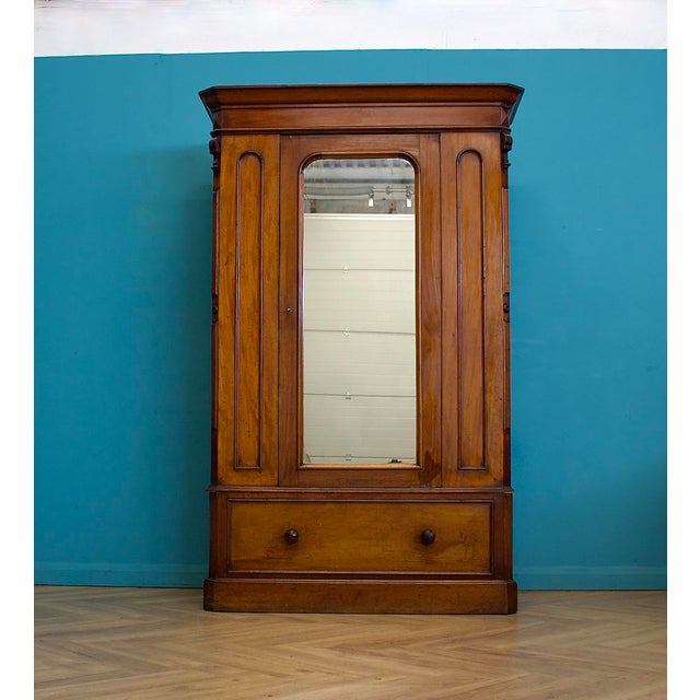 Late Victorian mahogany wardrobe with a mirrored centre door, moulded cornice and carved corner details, raised on a...
