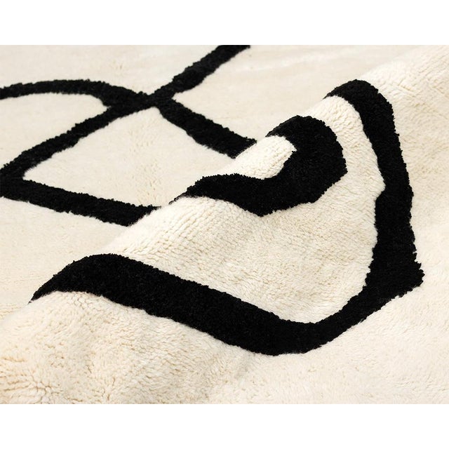 A single continuous line, transformed into art underfoot. This hand-knotted Moroccan rug distills abstract design down to...