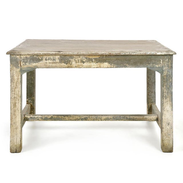 This antique table seduces with its simple lines and authentic patina. Made of solid wood, it retains the traces of a full...