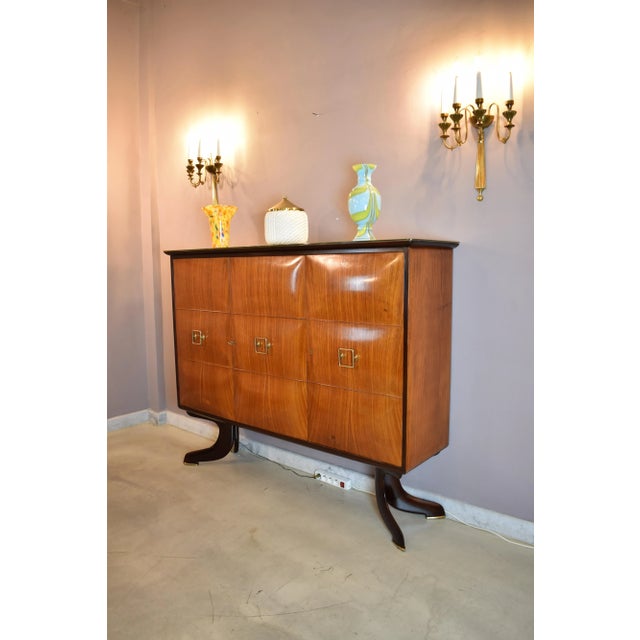 A large Italian bar cabinet attributed to Paolo Buffa, dating to the 1940s. The symmetrical case is executed in richly...