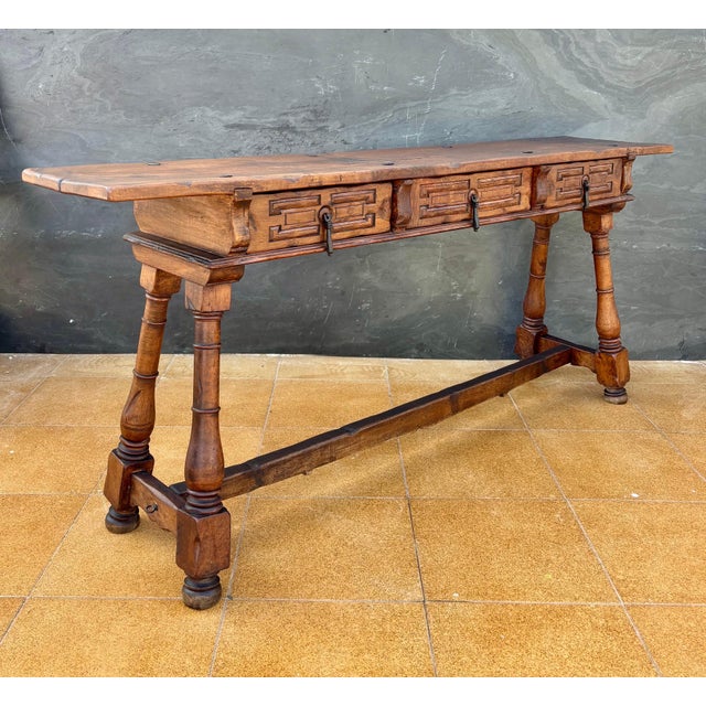 Spanish Renaissance Revival console table crafted in solid wood, mid-20th century. The piece features a thick plank-style...