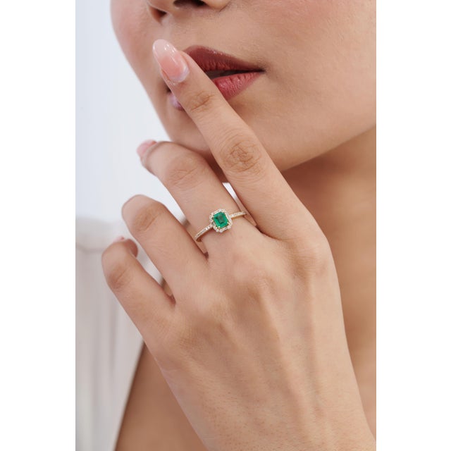 This emerald halo ring features a 0.48-carat emerald-cut green emerald, set in 14k yellow gold. The center stone measures...