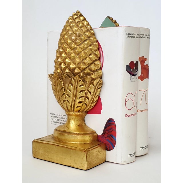 Offering a pair of 1960s gold leafed (gilded) plaster pineapple bookends, both signed Borghese with their original labels....