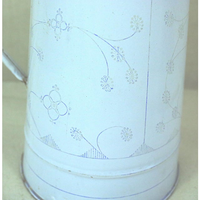 A decorated enamelled water pitcher made in Belgium in the late 19th century. This is a traditional item that could be...