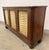 An English Regency style sideboard in rosewood with brass breakfront grillwork, circa 1950s. Inside features adjustable...