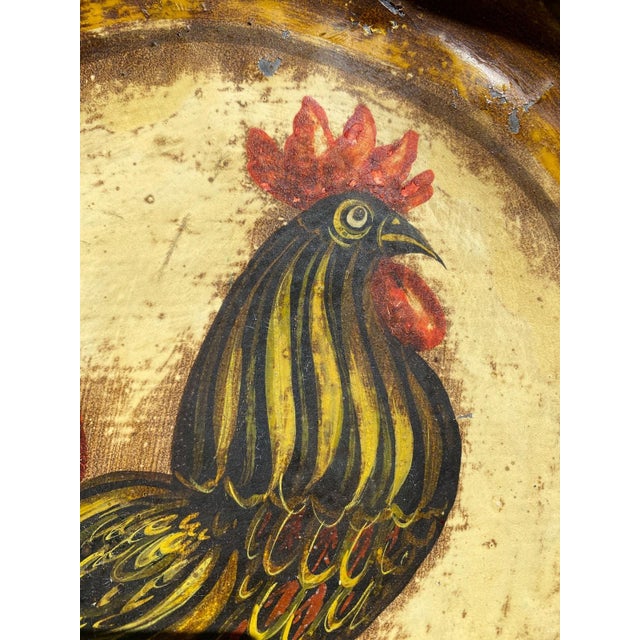 Signed hand-painted metal bowl by American folk artist Peter Ompir (1904–1979), featuring a vibrant rooster at the center...