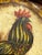 Signed hand-painted metal bowl by American folk artist Peter Ompir (1904–1979), featuring a vibrant rooster at the center...