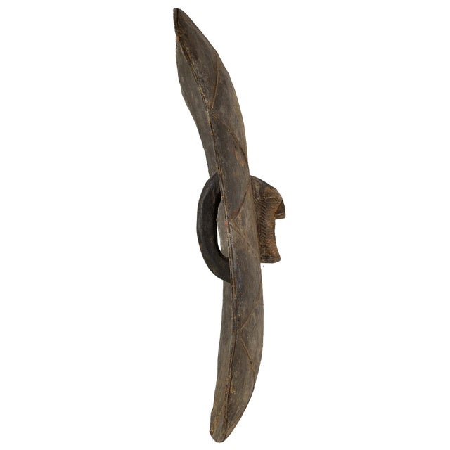 The wooden shield featuring a Kifwebe mask at its center was prevalent in the Songye region during colonial and pre-...