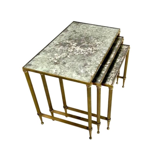 Vintage Set of Three Mid Century French Maison Jansen Style Brass Nesting Tables. They are a timeless ensemble that bring...