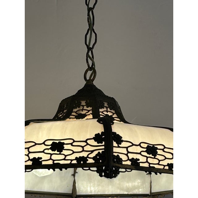 Beautiful Victorian Tiffany style chandelier having white milk glass adorned with bronzed metal overlay. 4 bulb sockets...