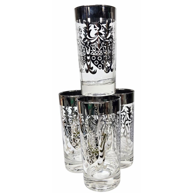 These 1970s tumblers are all that- complete with a thick silver stripe and an ornately designed suit of arms. One glass...