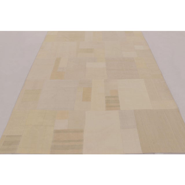 Handwoven in wool and cotton, this 6x8 vintage patchwork rug, circa 1950–1960, is a refined example of Turkish textile...