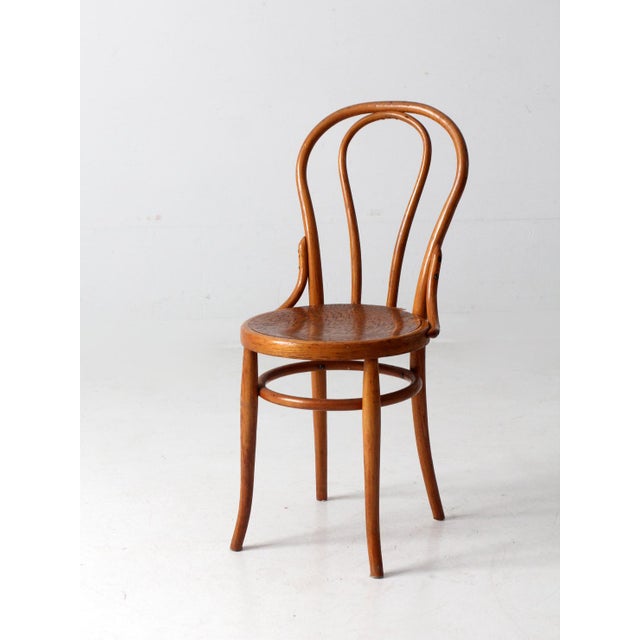 This is a bentwood chair circa early 20th century. The Thonet style cafe chair has a classic shape with a beautiful honey...