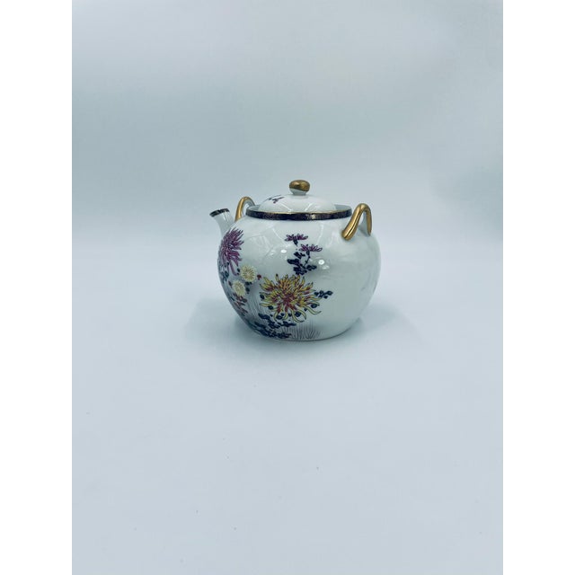 A Japanese teapot in the Kutania style, made of high-quality white porcelain. The teapot features a matching lid and two...