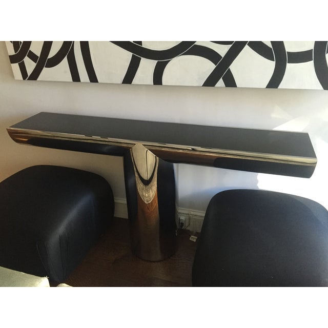 A late 20th century console table in polished stainless steel with black glass top and sides, by J. Wade Beam for Brueton,...