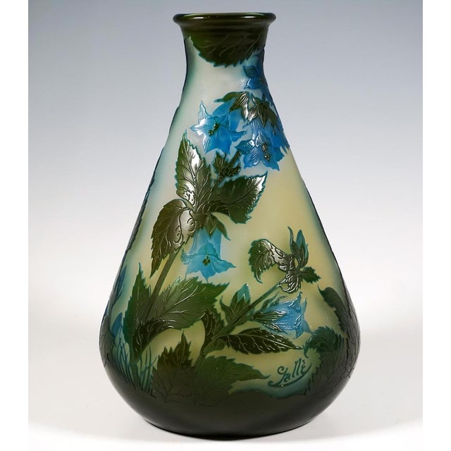 Large teardrop-shaped vase on a flush base, with a narrow opening and flared rim, colourless glass with milky yellow...