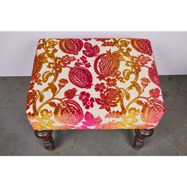 A hand-carved, 18th c., Italian walnut bench on turned legs and stretchers, now upholstered in a vibrant, contemporary,...