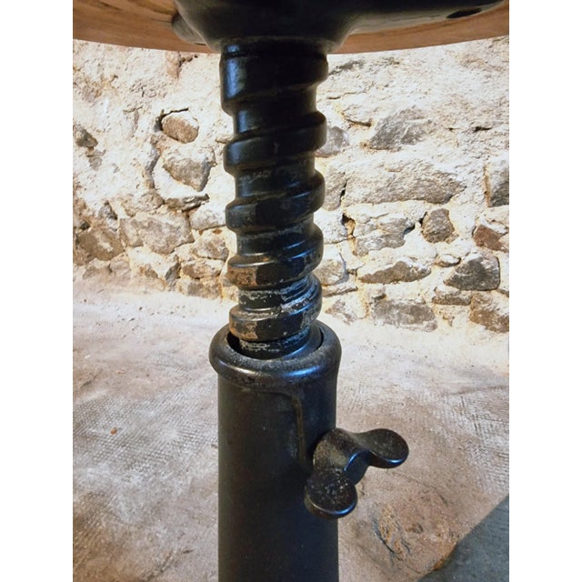 An authentic industrial Singer swivel stool dating from around 1930–1950, featuring a cast iron base with the embossed...