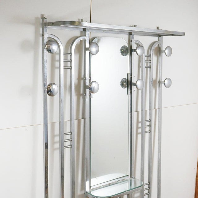 An Art Deco modernist Hall Stand. Polished chrome frame with mirrored central console mirror, upper hat racks, coat rails...