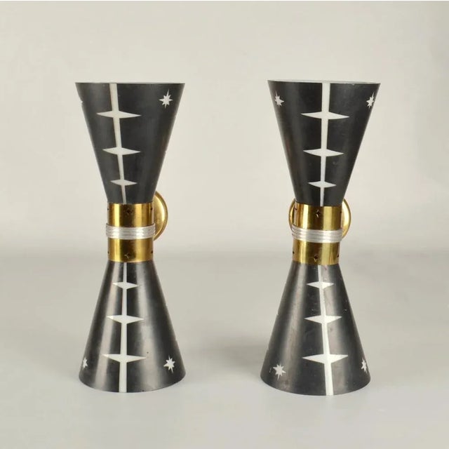 Unique large hourglass wall sconces designed with up and down light from the conical blown glass shades are etched to...