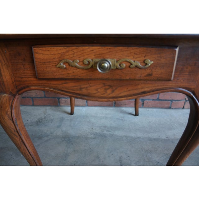 Country French end table from the Four Centuries Collection by Henredon. Finely crafted of oak featuring one drawer with...
