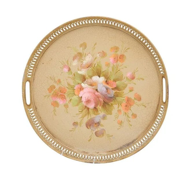 A French round tôle tray from the 20th century with hand-painted décor depicting a bouquet of roses, and pierced gallery....