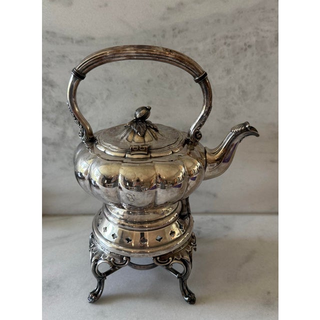Early 20th century English Sheffield silver plate tilting tea or coffee pot with a matching footed warming stand....