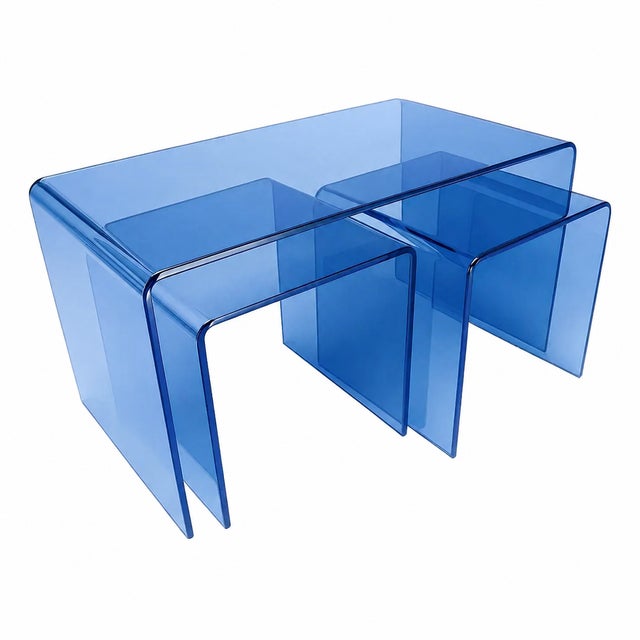 Elevate your living space with this striking set of three transparent blue acrylic nesting tables—where modern minimalism...