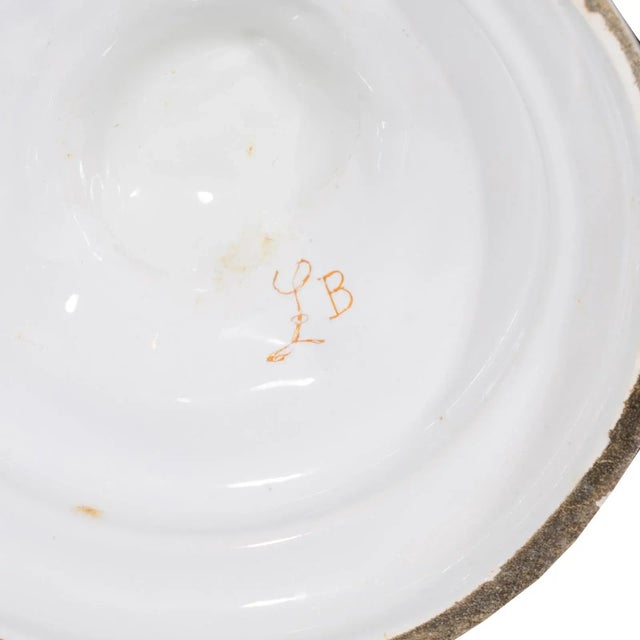 A fine pair of French faience Louis XVI Style candlesticks. Each decorated with delicate floral blossoms and vines....