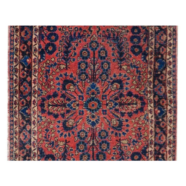 A beautiful early 20th century Persian Sarouk rug with a traditional mirrored floral pattern woven with myriad floral and...
