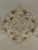 Handsome framed textile artwork by Trowbridge, featuring an elaborate symmetrical floral medallion embroidered on natural...