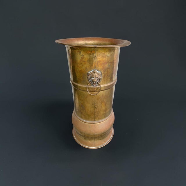 Striking antique brass umbrella stand or floor vase with an elegant, elongated form and distinctive historic double-headed...