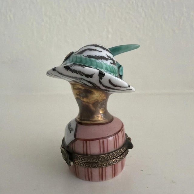 This now-retired Chanille Limoges trinket box features a charming Chapeaux De Paris Rose design with a pink color scheme....