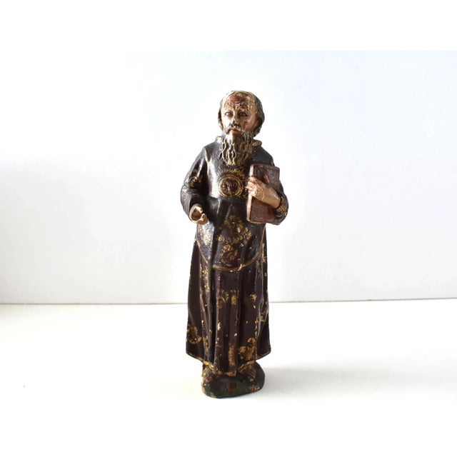 An antique Spanish Colonial santos of carved wood with gesso, gilt, and polychrome paint. Holding a book and in apostolic...